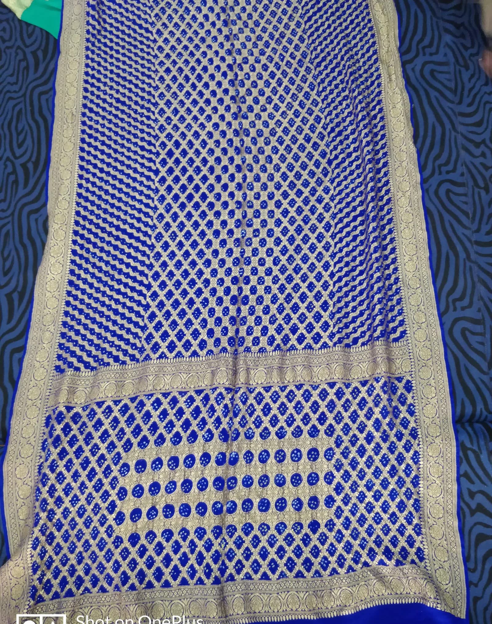 A crepe silk fabric with Banarasi zari border and bandhani tie-dye dot pattern