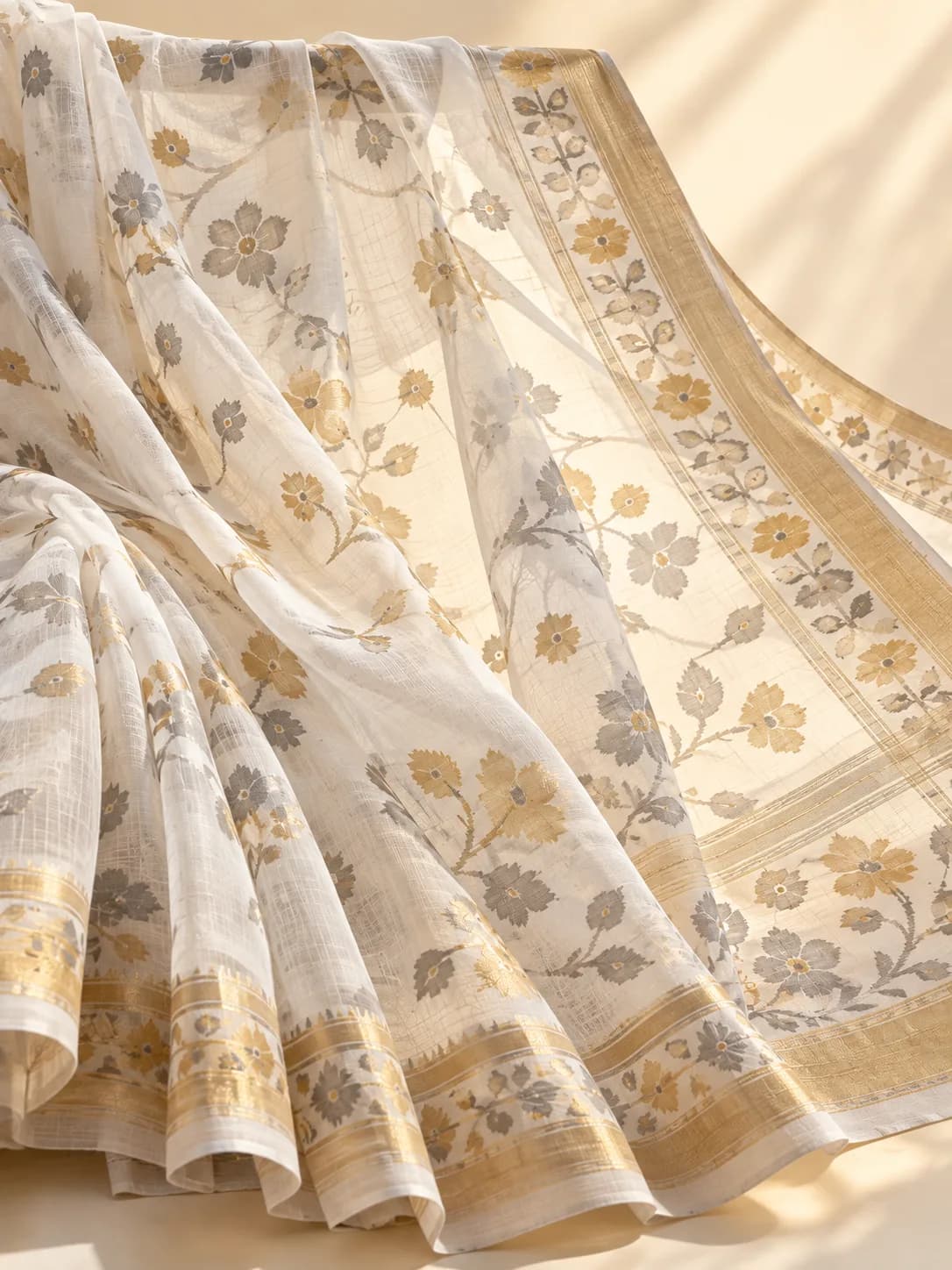 A white Jamdani saree with floral motifs floating on sheer cotton muslin