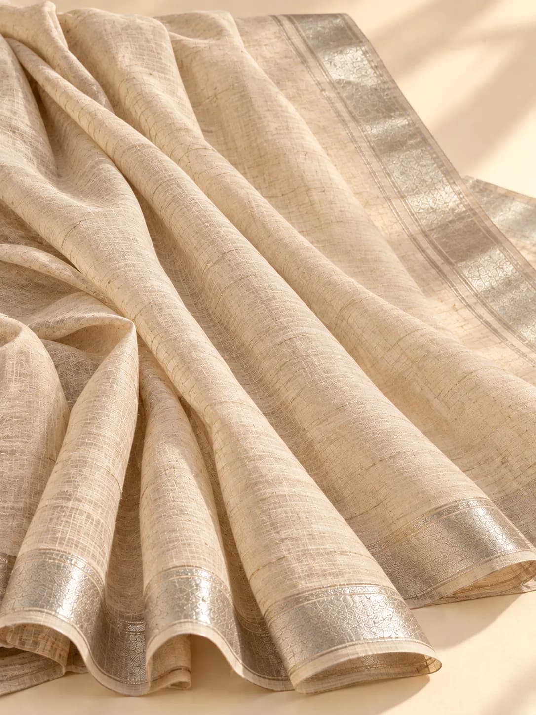 A natural beige linen saree with a slubbed weave and a thin silver border