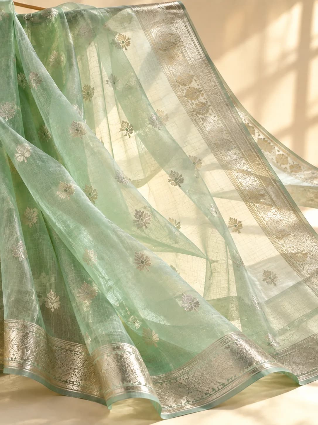 A sheer mint organza saree with silver zari buttis, crisp enough to hold its folds