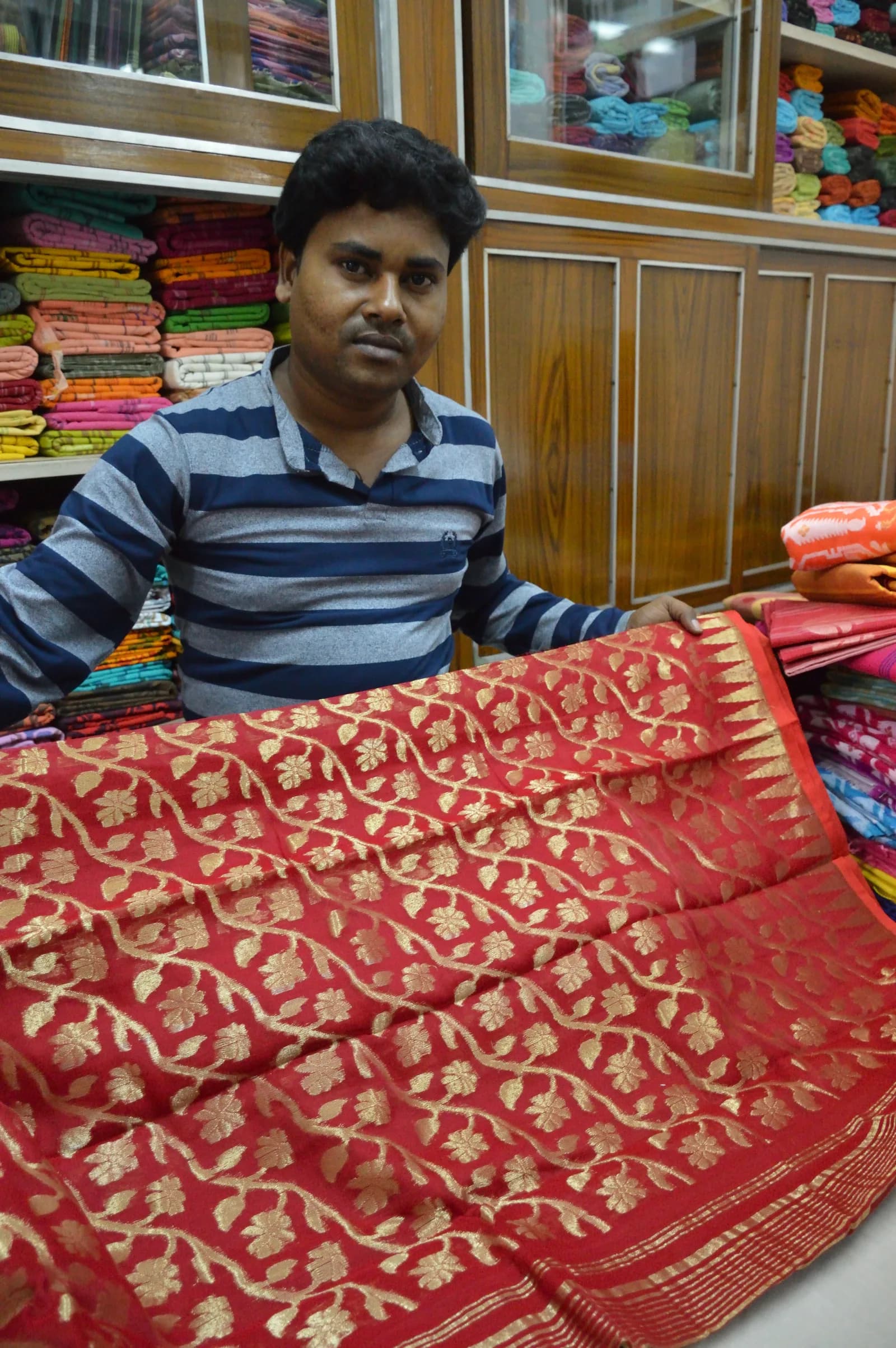 A weaver showing a handwoven tussar saree in Phulia, West Bengal